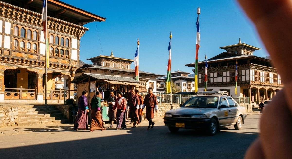 不丹帕羅街景，展現傳統木造建築、身穿國服的人群、經幡以及一輛銀色計程車，畫面右側有部分手指遮擋。